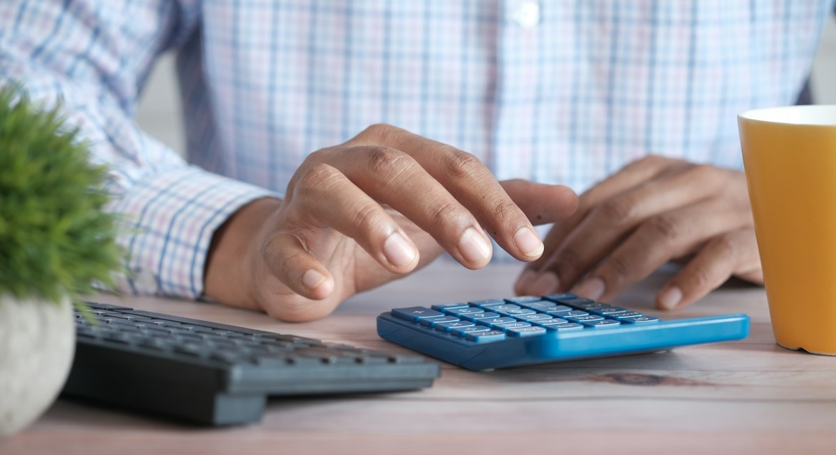 Proofreading fiyatları için hesap makinesi ve belgelerle çalışan kişi